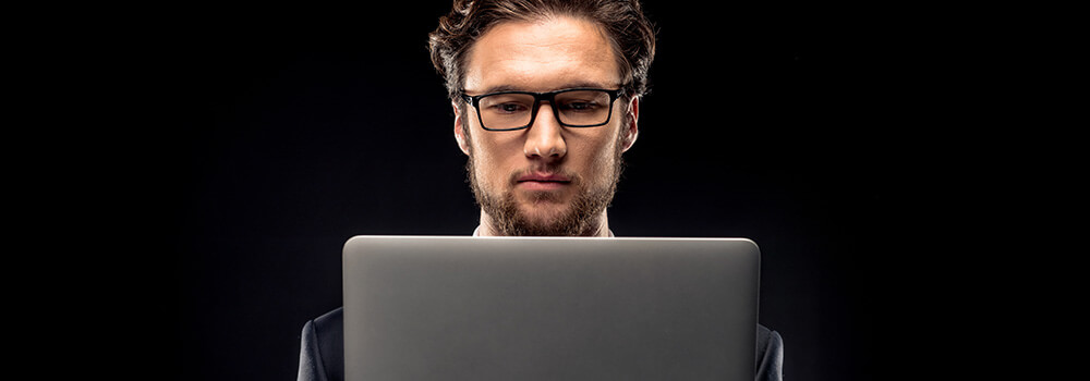 image of a man using a laptop, intently reading a website with professional website content writing